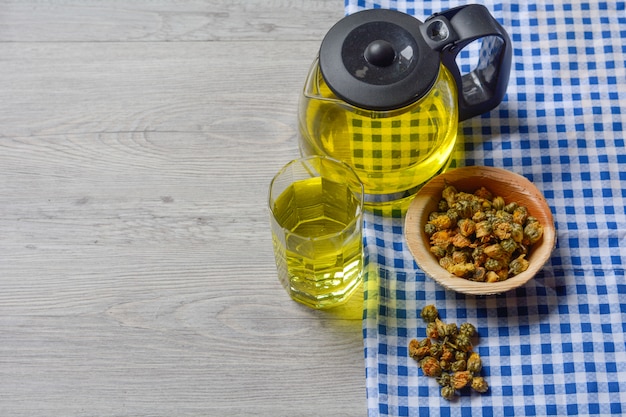 chrysanthemum tea with dried chrysanthemum tea in a wooden bowl on the table