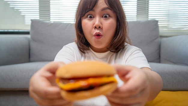 Chubby Asian woman express happiness When eating Hamburger