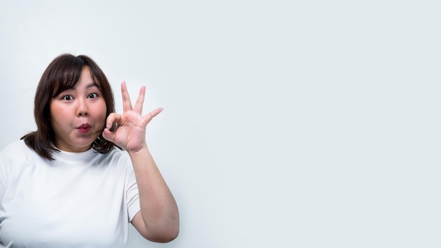 Chubby Asian woman Show different gestures with facial expressions and pointing by hand represents a symbol of communication on a white background for Copy space