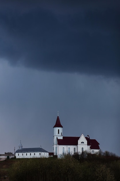 Church on the background of a gloomy sky before a thunderstorm. Faith and religion