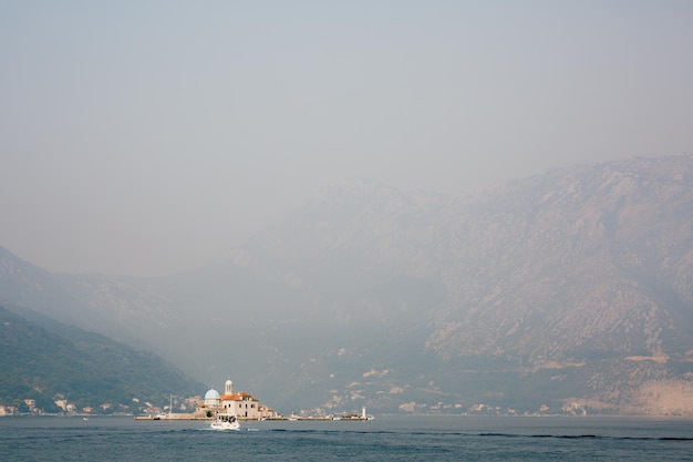 Church of our lady on the rocks against the background of mountains in the fog montenegro