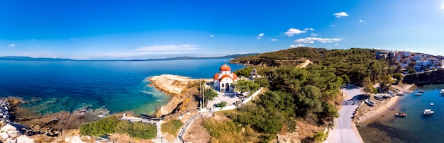 Church and sea with beach and mountains in Nea Roda, Halkidiki, Greece