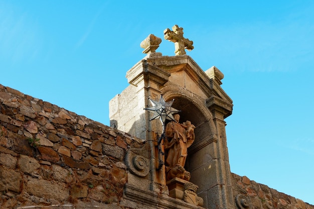 Church wall with a statue of the virgin mary and a starshaped lamp in Caseres Extremadura Spain