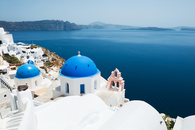 Church with blue domes in Oia town, Santorini island, Greece. Beautiful landscape with sea view