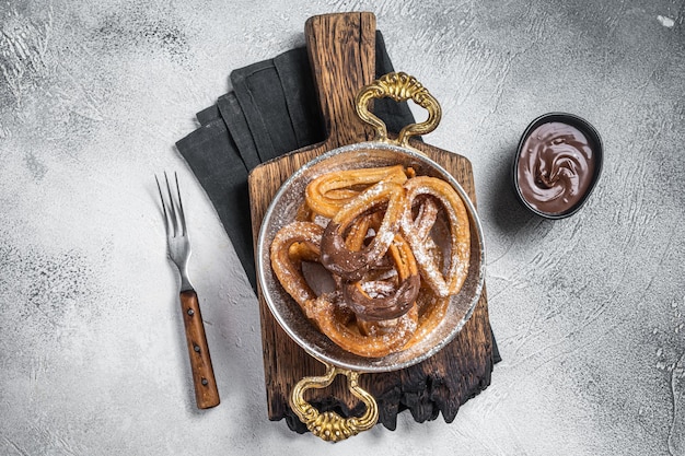 Churros con chocolate typical Spanish sweet snack in a skillet Gray background Top view