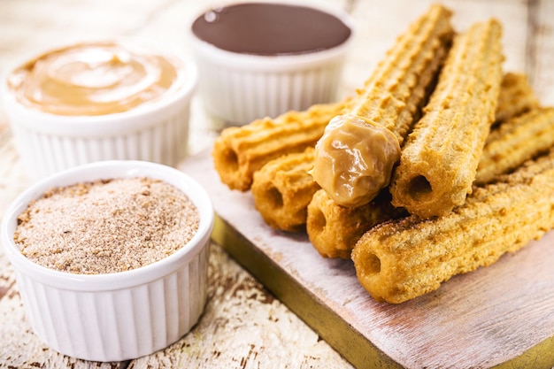 Churros fried sweet with granulated sugar filled with dulce de leche or creamy chocolate