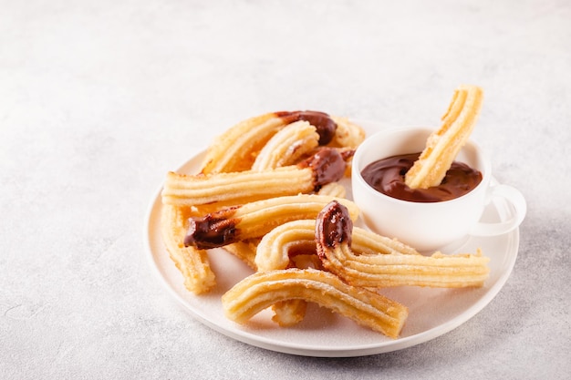 Churros with powdered sugar and chocolate sauce.