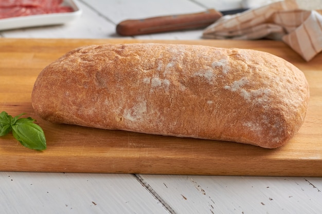 Ciabatta is an Italian white bread made from wheat flour water salt yeast olive oil on white wooden background