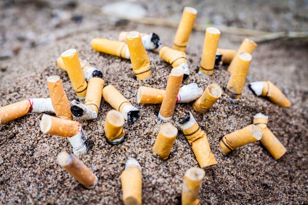 Cigarette in ashtray on sand