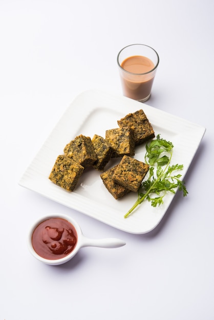 Cilantro cake or Kothimbir Vadi is a popular maharashtrian cuisine made with cilantro leaves. served with tomato ketchup. selective focus