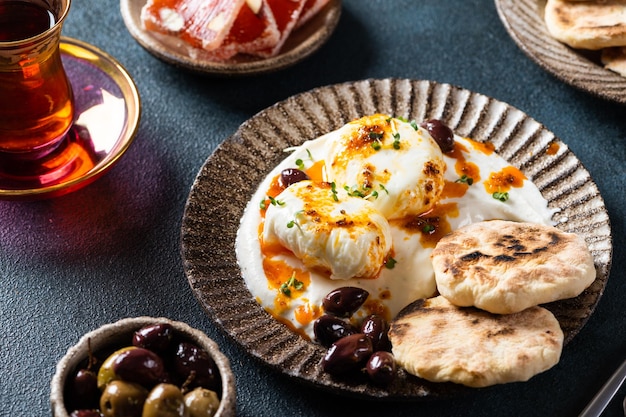 Cilbir or Turkish Eggs mezze poached eggs topped over herbed greek yogurt then drizzled with hot spiced paprika olive oil Traditional Turkish breakfast with rahat