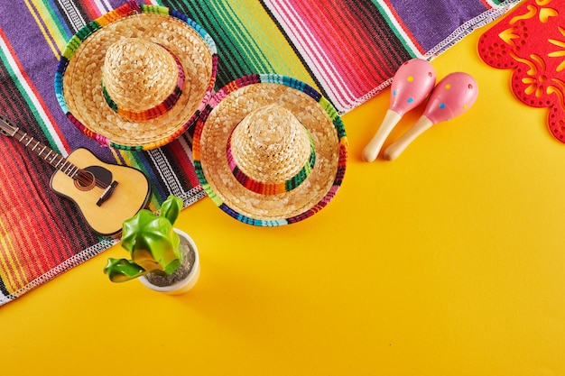 Cinco de mayo holiday background maracas cactus and hat on yellow background