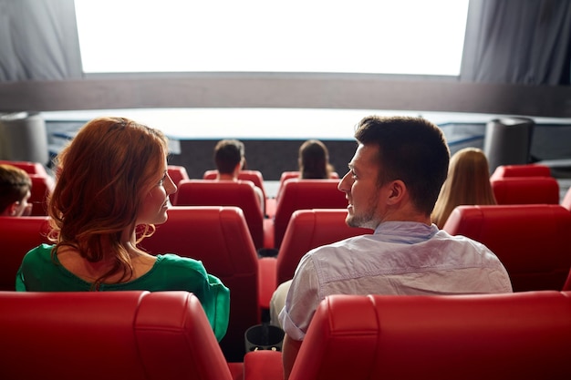 cinema, entertainment, leisure and people concept - couple watching movie in theater from back