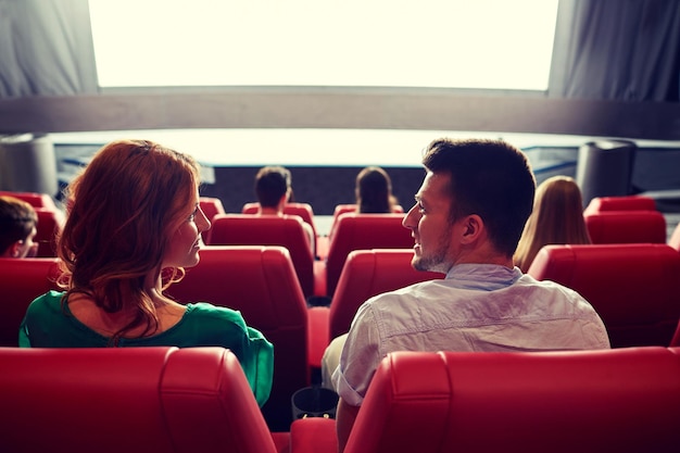 cinema, entertainment, leisure and people concept - couple watching movie in theater from back