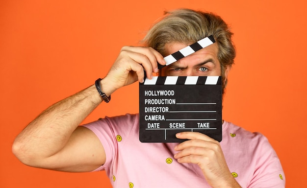 Cinema production. Creative producer. Bearded man hold movie clapper. Film maker. Clapperboard copy space. Comedy or drama. Watch movie. Film director. Actor casting. Shooting scene. Favorite series.