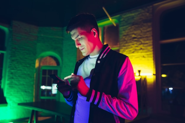 Cinematic portrait of handsome young man in neon lighted room stylish musician