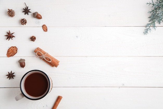 cinnamon,anise stars,fir branches and a Cup of hot chocolate on a white wooden background. Flat lay. top view