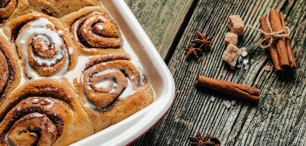 Cinnamon rolls with white cream sauce Long banner format top view