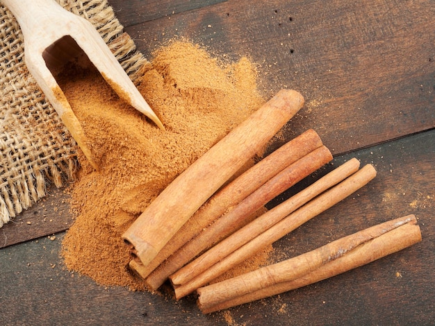 Cinnamon sticks and cinnamon powder in wooden scoop