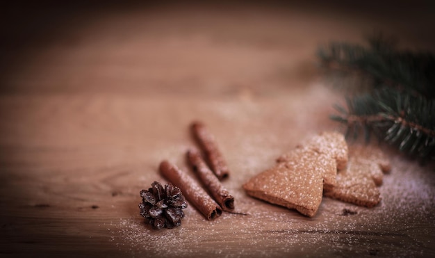 Cinnamon sticks cookies and christmas tree branch but the tabl