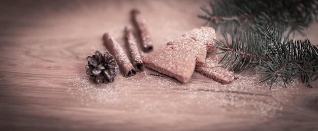 Cinnamon sticks cookies and Christmas tree branch but the tabl