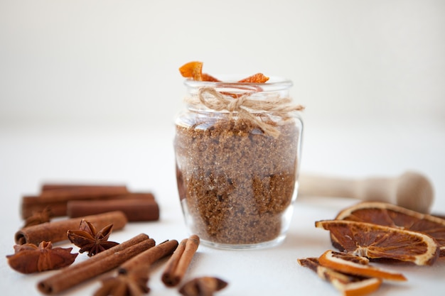 Cinnamon sticks dried oranges and star anise with brown sugar bottle with shallow depth of field