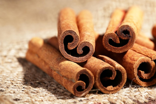 Cinnamon sticks on sackcloth on table close up