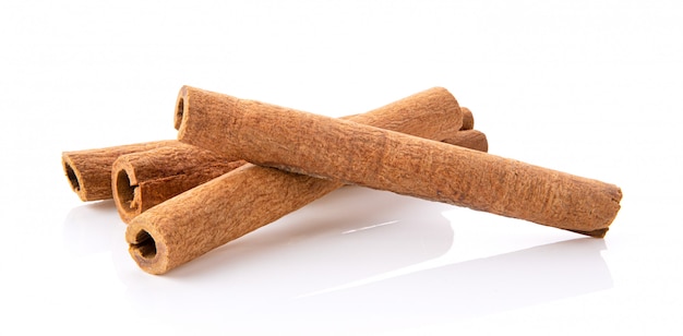 Cinnamon sticks stacked on white