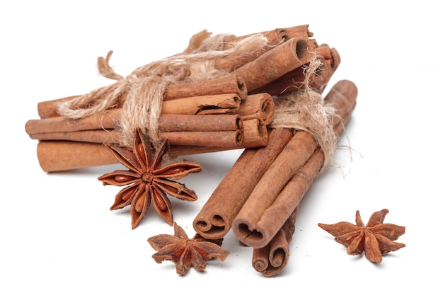 Cinnamon sticks and star anises on white surface