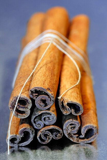 Cinnamon sticks tied with a string isolated on a gray background.