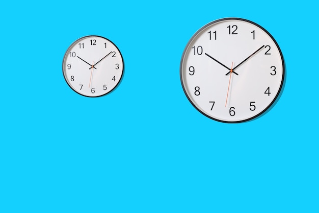 Circular white clock on blue wall background