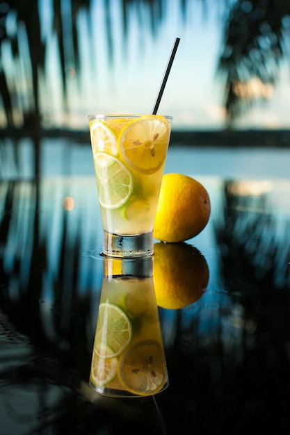 Citric drink cocktail on tropical background