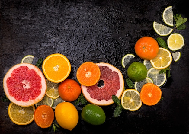 Citrus background. Fresh citrus fruits - Lemons, oranges, limes, grapefruits on wooden background.