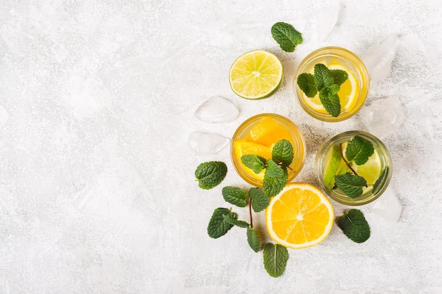 Citrus detox drinks or cocktails with mint and slices of fruit.