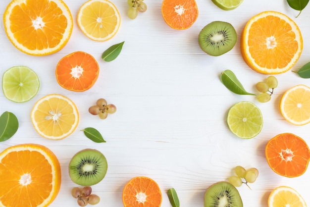 Citrus fruits and kiwi cut into circles grapes on a white background with space for text Poster banner article