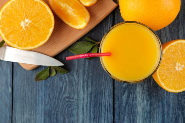 Citrus juices. Orange juice with fresh oranges on a blue wooden table. view from above. space for text