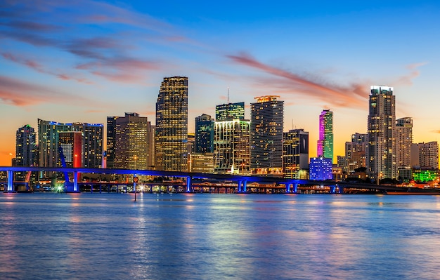 CIty of Miami Florida, summer sunset panorama with colorful illuminated business and residential buildings and bridge on Biscayne Bay