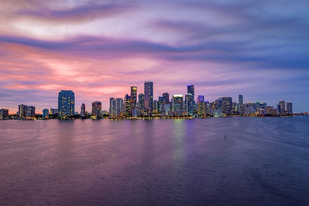 City of Miami Florida, sunset panorama with business and residential buildings and bridge on Biscayne Bay. Skyline night view.