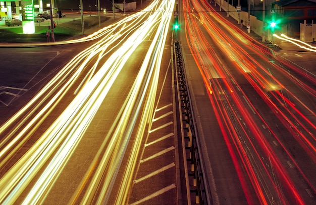 City roads and moving car with blur light through. Green light is shown.