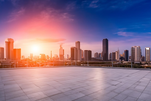 a city skyline with the sun setting behind it