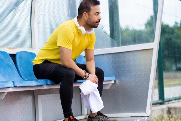 city sports stadium the bearded sportsman with headphones and a towel