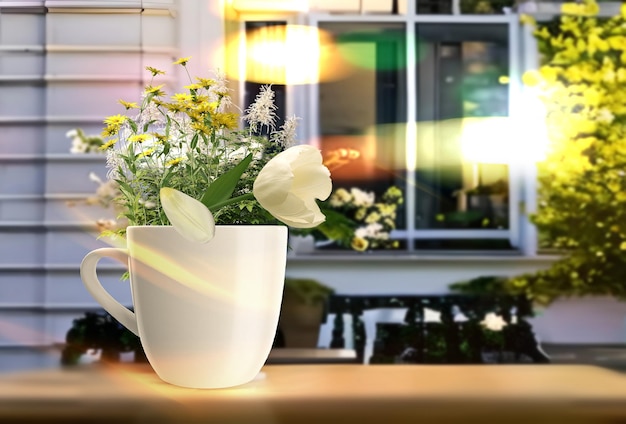 City Street cafe flowers and a cup of coffee on a table in the city in summer houses and blue sky