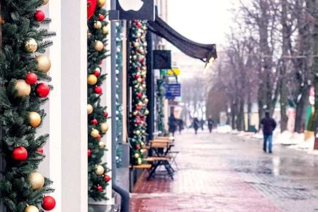 The city street is decorated with fir branches and toys on Christmas Eve