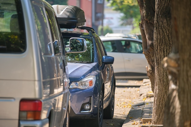 City traffic with cars parked in line on street side.