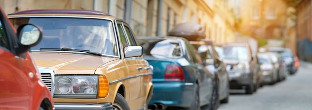 City traffic with cars parked in line on street side.