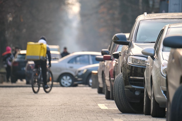 City traffic with cars parked in line on street side.