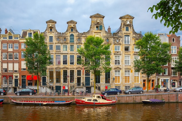 City view of Amsterdam canals and typical houses, boats and bicycles, Holland, Netherlands.