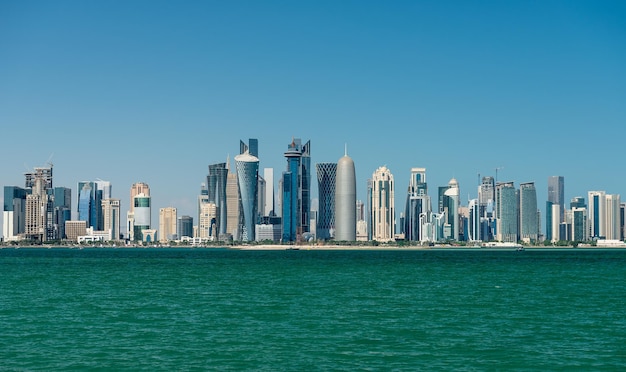 City at waterfront against blue sky