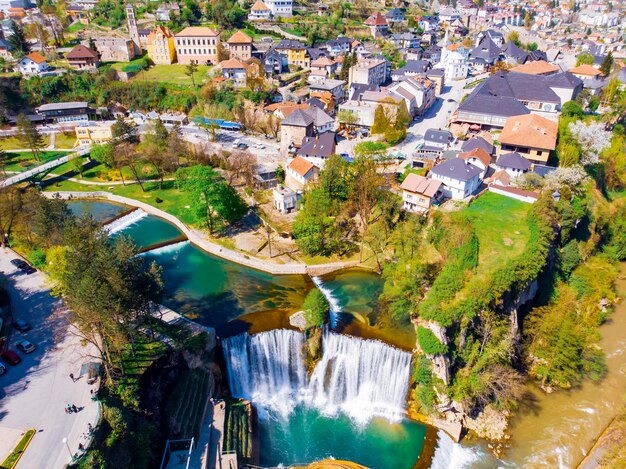 Photo a city with a river running through it and a waterfall in the middle