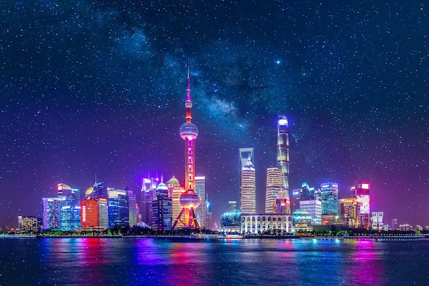 Cityscape of Shanghai at twilight sunset with stars and Milky Way. Panoramic view of Pudong business district skyline from the Bund.